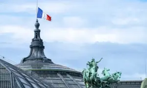 Le drapeau français flotte au sommet d'une tour du palais des congrès Paris, à côté d'une statue de quadrige.