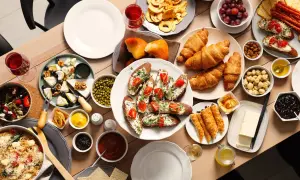 Un délicieux brunch en famille avec croissants, toasts garnis, fromages, fruits et pâtes.