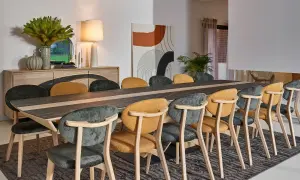 Salle à manger élégante, parfaite pour un restaurant gastronomique à Paris. Table en bois et céramique, chaises confortables aux couleurs chaudes et sombres.