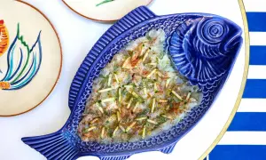 Un délicieux carpaccio de poisson servi dans un plat bleu en forme de poisson, parfait pour un déjeuner à Paris.