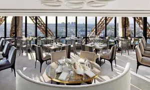 Un restaurant cool pour ado avec vue panoramique sur Paris. Tables dressées, sièges confortables, ambiance chic.