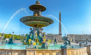 Fontaine monumentale et obélisque sur la place de la Concorde, Paris, sous un ciel bleu éclatant.