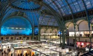 Vue intérieure du Grand Palais à Paris, une exposition d'art se déroule sous sa verrière spectaculaire.