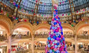 Arbre de Noël féerique fait de bonbons et étoiles, décorations colorées suspendues sous la coupole d'un grand magasin parisien.