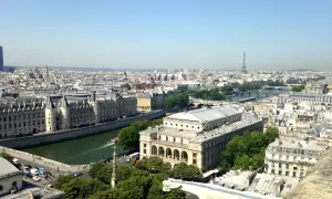 Vue panoramique de Paris, zone 1 à 3, avec la Seine, des bâtiments historiques et la Tour Eiffel au loin.