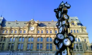 Sculpture de multiples horloges devant la gare Saint-Lazare, un monument parisien où le temps s'est arrêté.