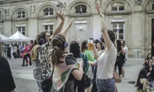Des gens dansent avec des casques lors d'un concert silencieux devant l'Hôtel de Ville de Paris.