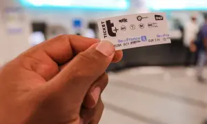 Main d'une personne tenant un ticket de métro parisien, prêt pour un voyage dans la ville.