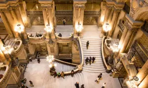 Vue aérienne de l'escalier monumental du Palais Garnier avec des visiteurs.
