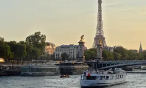 Une belle balade sur Seine à Paris, avec la Tour Eiffel et le pont Alexandre III en arrière-plan. Un bateau navigue paisiblement sur l'eau.