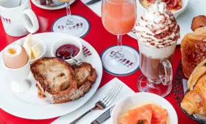 Un délicieux brunch avec enfants : toasts, œuf à la coque, confiture, jus d'orange, chocolat viennois et viennoiseries.