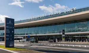 La navette Paris Orly attend devant l'aéroport. Panneaux indicateurs pour les entrées, départs et arrivées.
