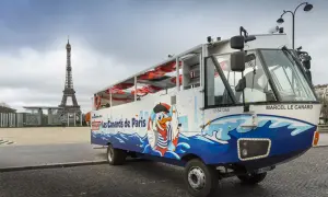 Un bus amphibie "Les Canards de Paris" prêt pour un tour hop on hop off, avec la Tour Eiffel en arrière-plan.