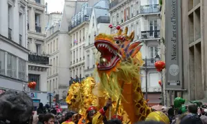 Un grand dragon doré danse dans les rues de Paris lors du défilé du nouvel an chinois, sous les regards émerveillés de la foule.