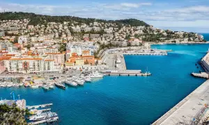 Vue panoramique du port de Nice, avec des yachts amarrés et des bâtiments colorés. On imagine un repas chez Juliette, menu ensoleillé.