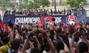Foule en liesse à Paris, le 14 juillet, pour célébrer les champions sur un bus à impériale. Les téléphones sont levés pour immortaliser l'instant.