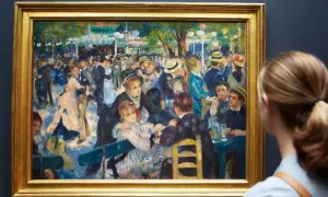 Une femme admire une peinture de Renoir représentant une scène animée de danseurs et de convives dans un jardin.