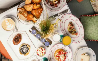 Un plateau de viennoiseries, tartes, œufs, jus et café pour un meilleur brunch parisien.