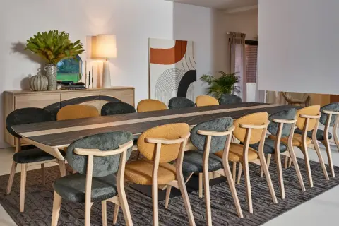 Salle à manger élégante, parfaite pour un restaurant gastronomique à Paris. Table en bois et céramique, chaises confortables aux couleurs chaudes et sombres.