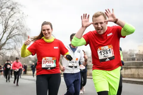 Joyeux coureurs au semi-marathon Paris 2026, une femme fait un pouce levé, un homme fait des grimaces.