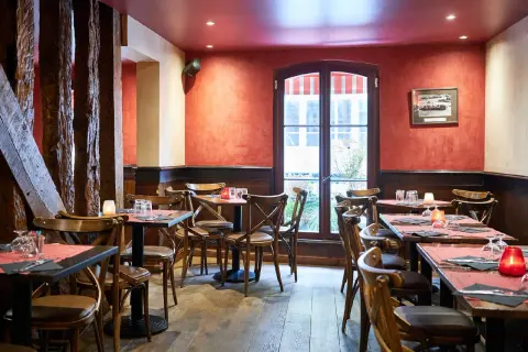 Ambiance chaleureuse au restaurant Le Molière, avec ses tables dressées, ses bougies et ses poutres apparentes.