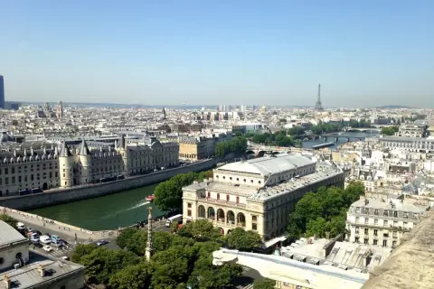 Vue panoramique de Paris, zone 1 à 3, avec la Seine, des bâtiments historiques et la Tour Eiffel au loin.