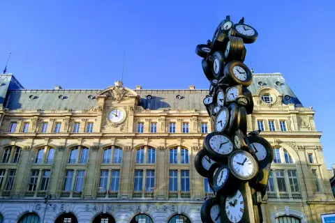 Sculpture de multiples horloges devant la gare Saint-Lazare, un monument parisien où le temps s'est arrêté.