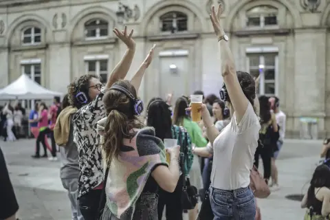 Des gens dansent avec des casques lors d'un concert silencieux devant l'Hôtel de Ville de Paris.