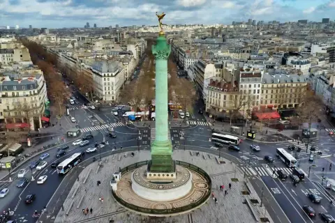Vue aérienne de la colonne de Juillet sur la place de la Bastille, avec le trafic parisien animé autour.