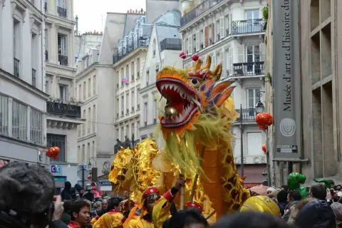 Un grand dragon doré danse dans les rues de Paris lors du défilé du nouvel an chinois, sous les regards émerveillés de la foule.