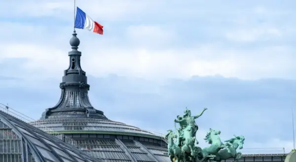Le drapeau français flotte au sommet d'une tour du palais des congrès Paris, à côté d'une statue de quadrige.