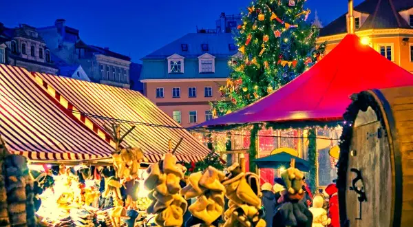 Ambiance féerique d'un marché de Noël en Île-de-France, avec un sapin illuminé, des chalets colorés et des décorations festives.