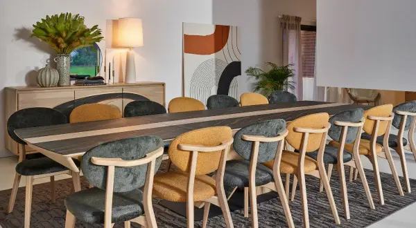 Salle à manger élégante, parfaite pour un restaurant gastronomique à Paris. Table en bois et céramique, chaises confortables aux couleurs chaudes et sombres.