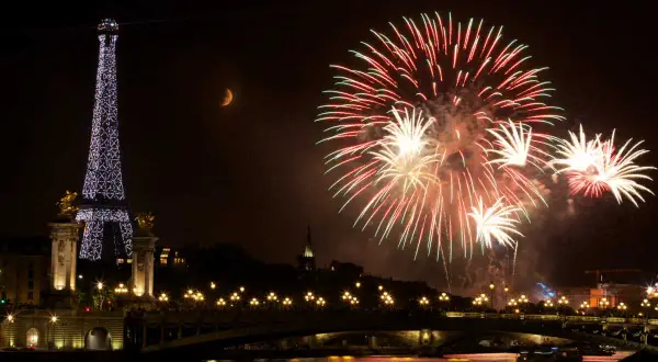 Feux d'artifice spectaculaires illuminent le ciel parisien, avec la Tour Eiffel scintillante et la lune en croissant. Une célébration mémorable pour le 3 avril férié.
