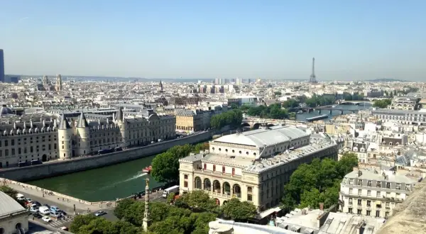 Vue panoramique de Paris, zone 1 à 3, avec la Seine, des bâtiments historiques et la Tour Eiffel au loin.