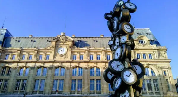 Sculpture de multiples horloges devant la gare Saint-Lazare, un monument parisien où le temps s'est arrêté.