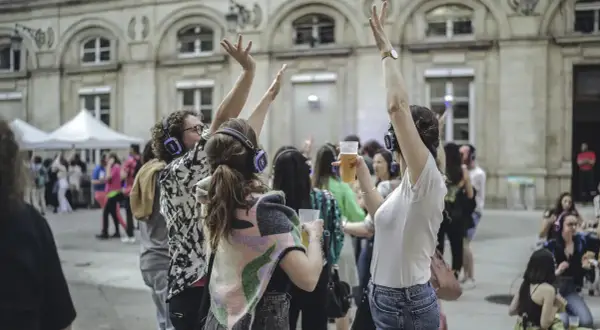 Des gens dansent avec des casques lors d'un concert silencieux devant l'Hôtel de Ville de Paris.