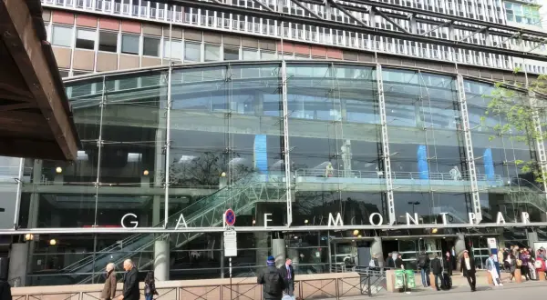 La gare de Montparnasse, avec sa façade de verre moderne, accueille des voyageurs pressés.