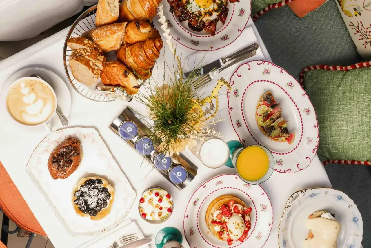 Un plateau de viennoiseries, tartes, œufs, jus et café pour un meilleur brunch parisien.