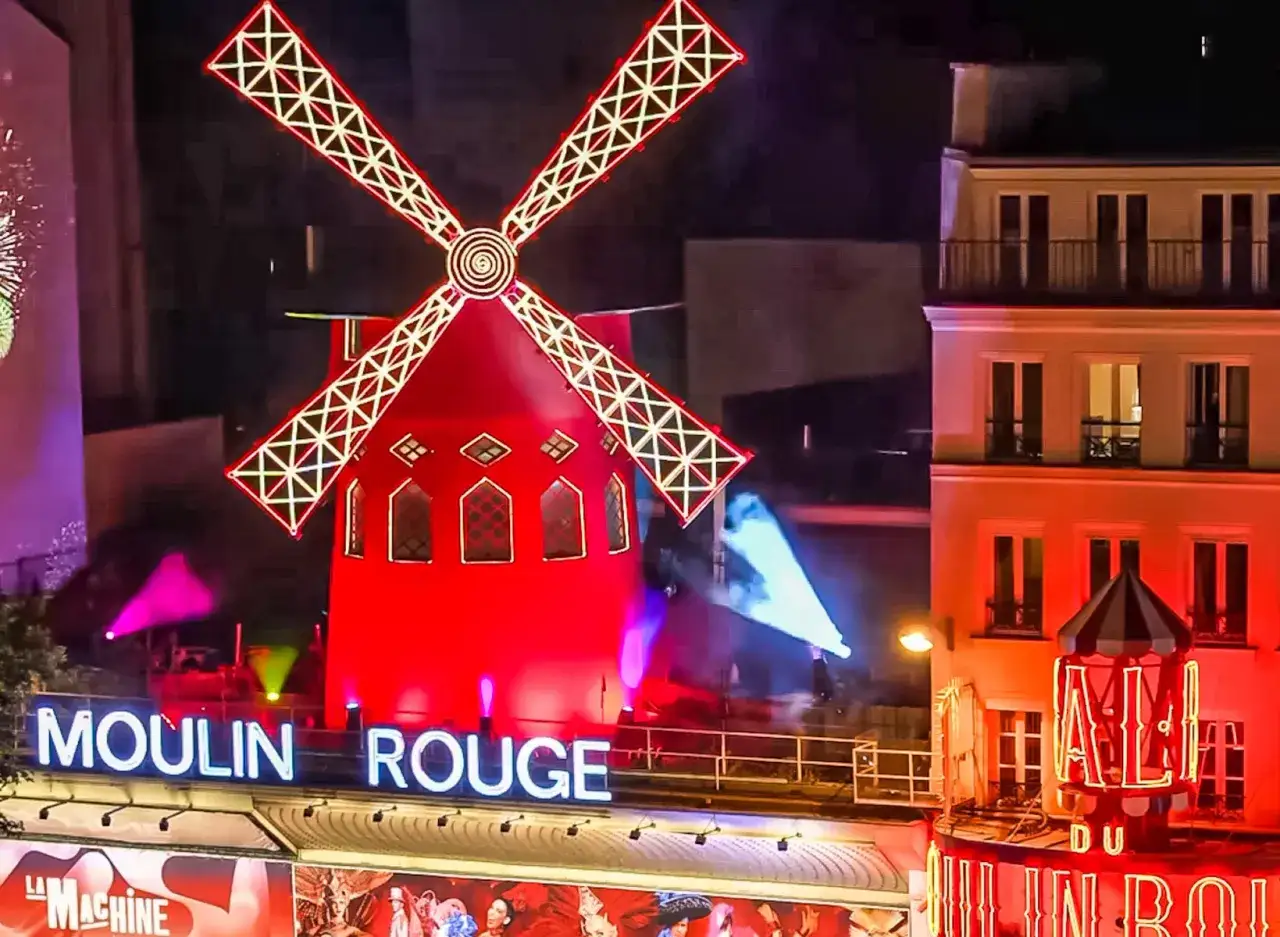 Le Moulin Rouge illumin&eacute; de nuit. Le prix d'entr&eacute;e pour ce spectacle parisien embl&eacute;matique est souvent demand&eacute;.