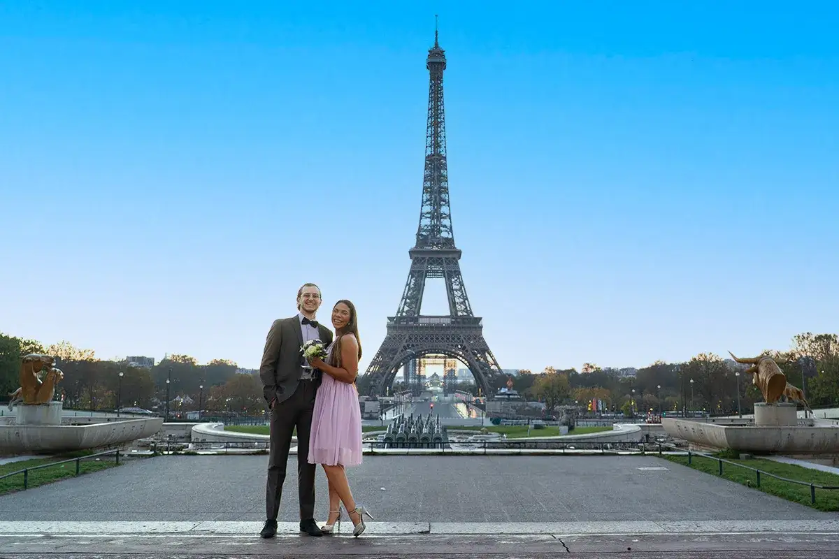 Un couple heureux devant la Tour Eiffel, avec le Palais de Chaillot en arrière-plan.