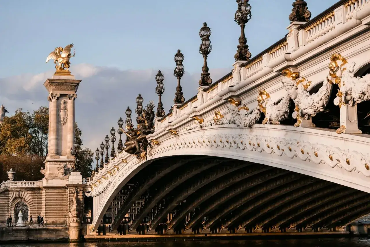 Magnifique balade sur Seine &agrave; Paris, le Pont Alexandre III orn&eacute; de ses lampadaires et sculptures dor&eacute;es, sous un ciel bleu et nuageux.