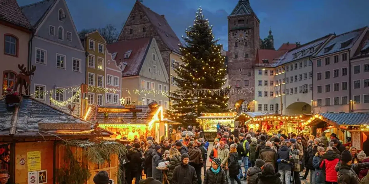 Marché de Noël animé, sapin illuminé, chalets en bois, ambiance festive. Une belle tradition de Noël en France.
