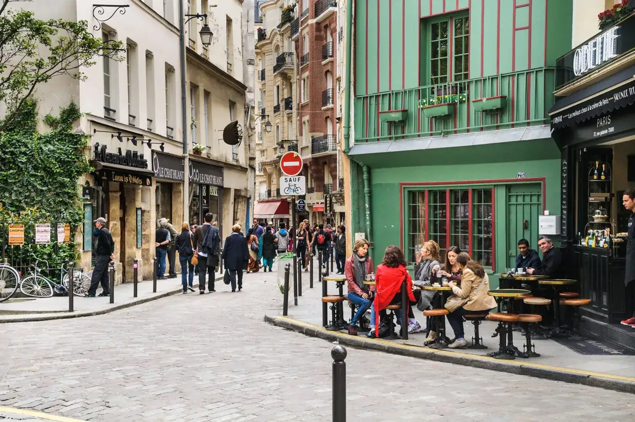 Rue pav&eacute;e &agrave; Paris, des &eacute;tudiants profitent d'un caf&eacute; en terrasse. Ambiance typique de quartier.