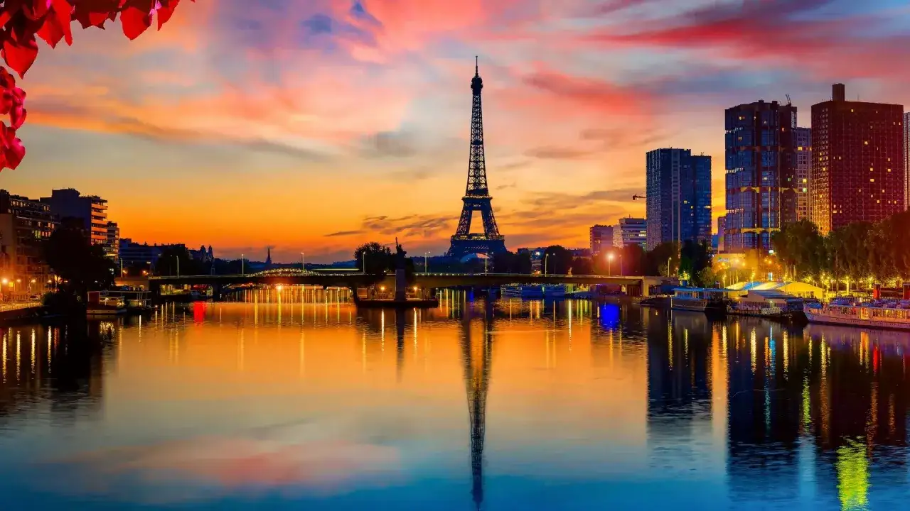 La Tour Eiffel se refl&egrave;te dans la Seine, sous un ciel aux couleurs flamboyantes. Paris ce soir, une vision magique.