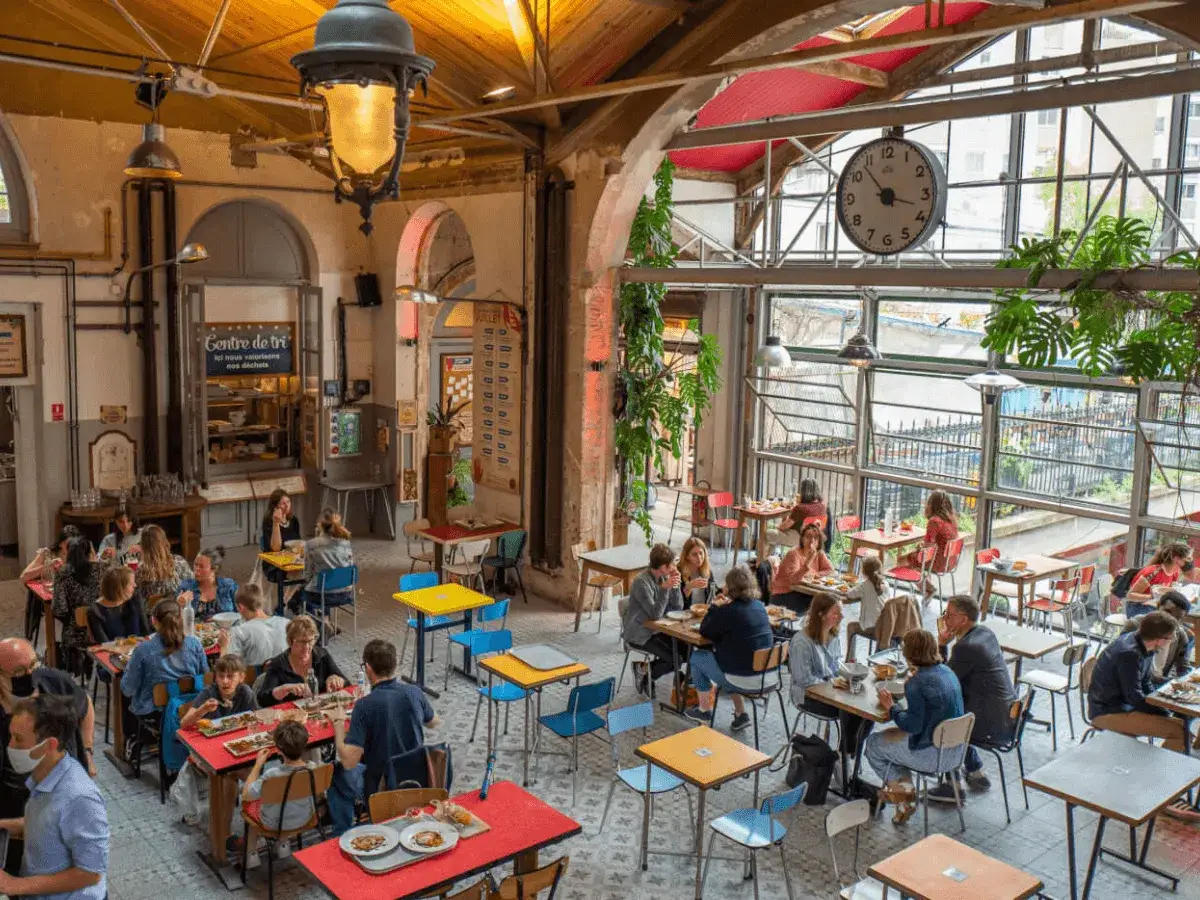Ambiance décontractée dans ce restaurant cool pour ado, avec ses tables colorées et sa grande horloge.