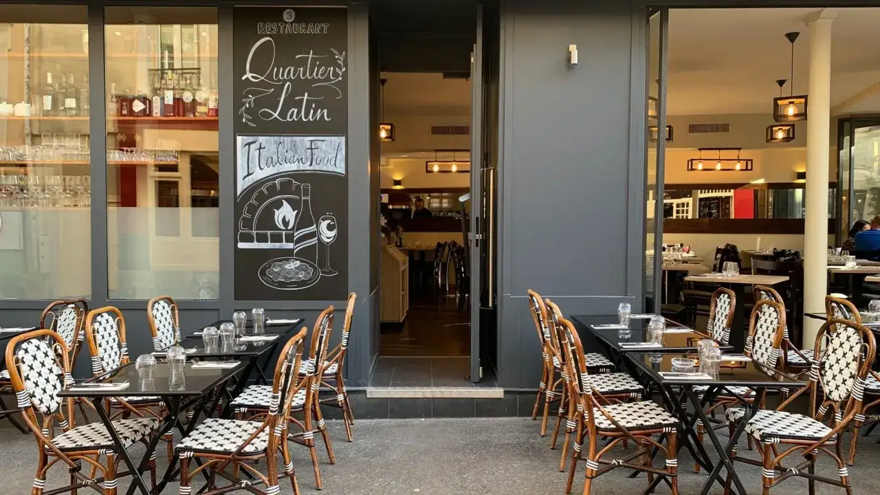 Terrasse de restaurants quartier latin. Tables dress&eacute;es, chaises en rotin, et une ardoise annon&ccedil;ant 