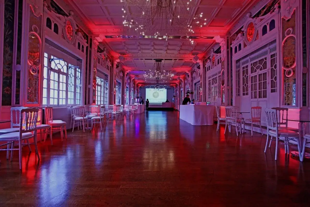 Un élégant auditorium à Paris, baigné de lumières rouges et bleues, prêt pour un événement.