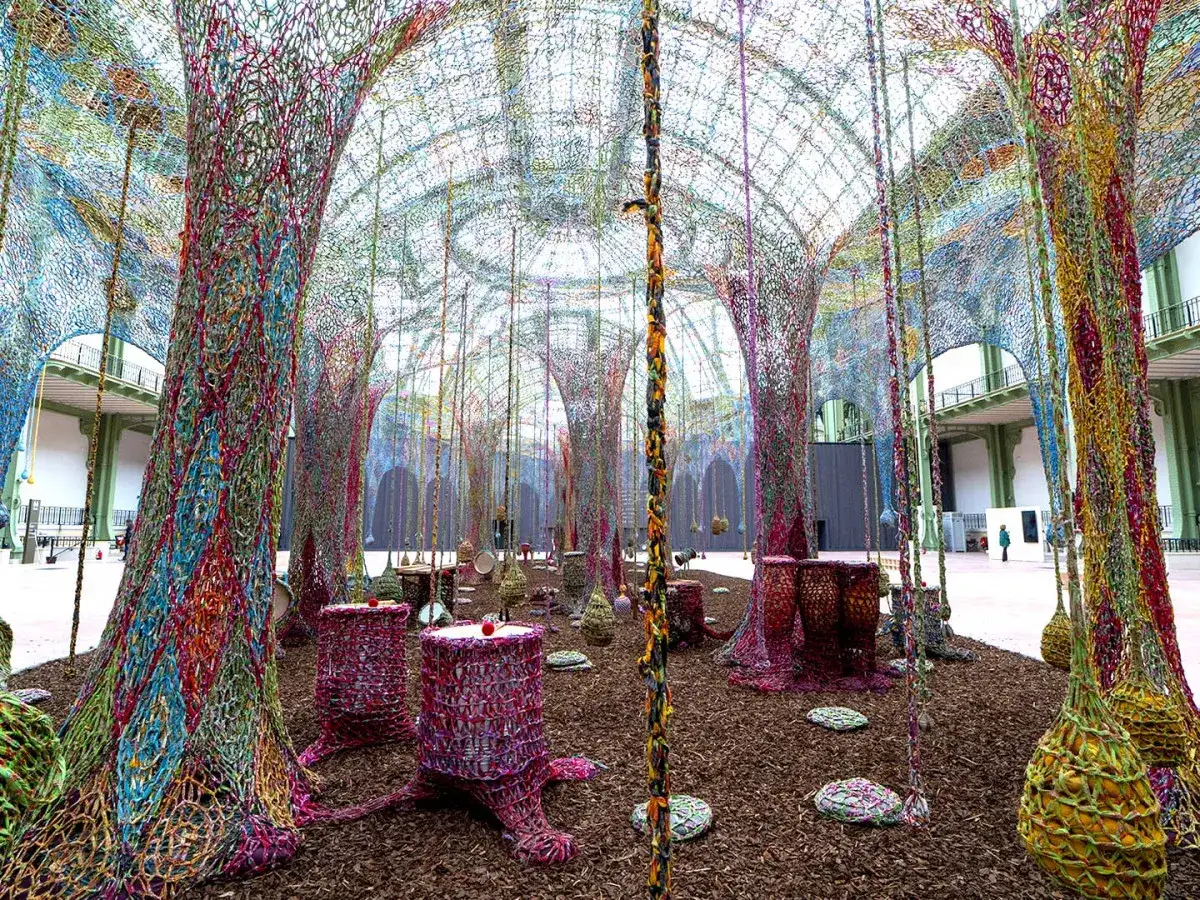 Installation artistique colorée dans un grand espace, évoquant une forêt enchantée. Une photo de Paris qui invite à la rêverie.