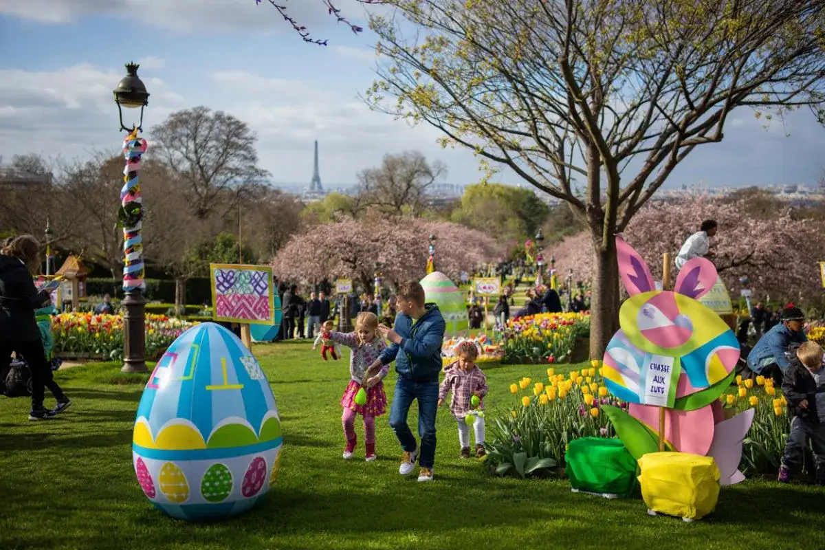 Joyeuse chasse aux &oelig;ufs &agrave; Paris, avec des enfants joyeux dans un parc fleuri, sous le regard de la Tour Eiffel.